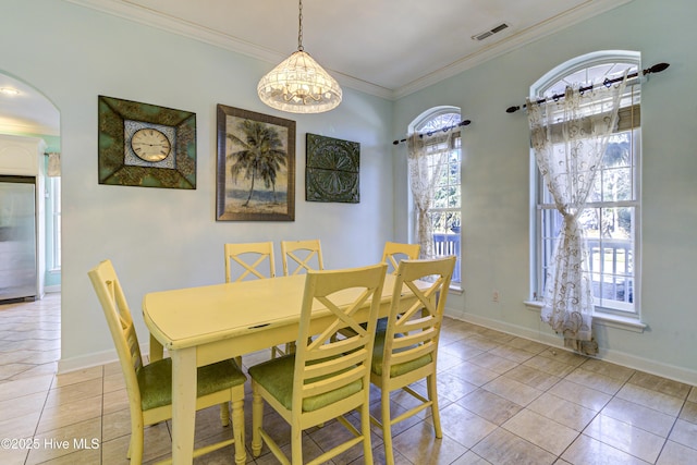 dining area featuring arched walkways, crown molding, visible vents, light tile patterned flooring, and baseboards