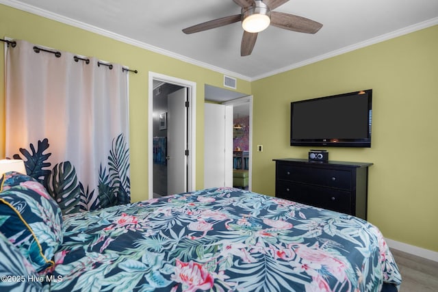 bedroom with a ceiling fan, visible vents, ornamental molding, and baseboards