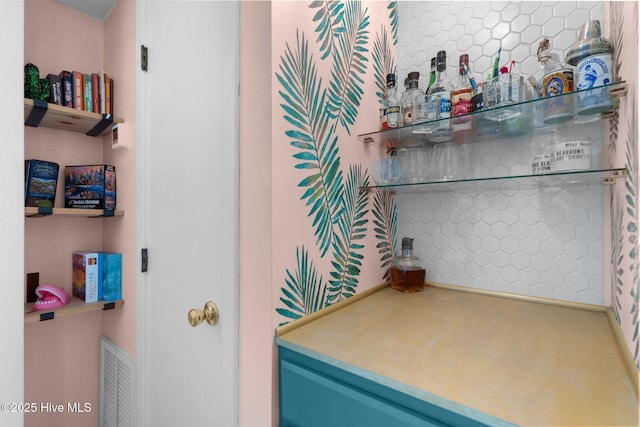 bar featuring a dry bar, backsplash, and visible vents