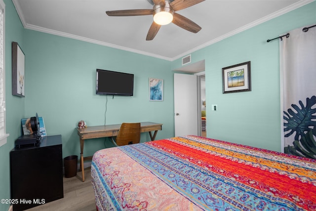 bedroom featuring a ceiling fan, crown molding, visible vents, and wood finished floors