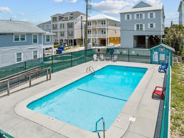 pool with a residential view and fence