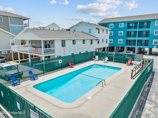 pool featuring a residential view, fence, and a patio