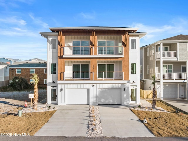 view of front facade with driveway, a balcony, a garage, and board and batten siding