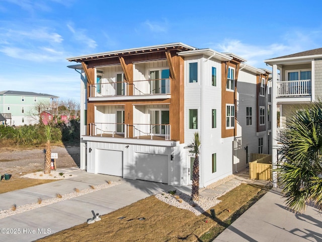 view of front of property with board and batten siding, driveway, a balcony, and an attached garage