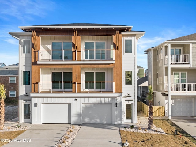 view of front of property with a balcony, an attached garage, board and batten siding, and concrete driveway