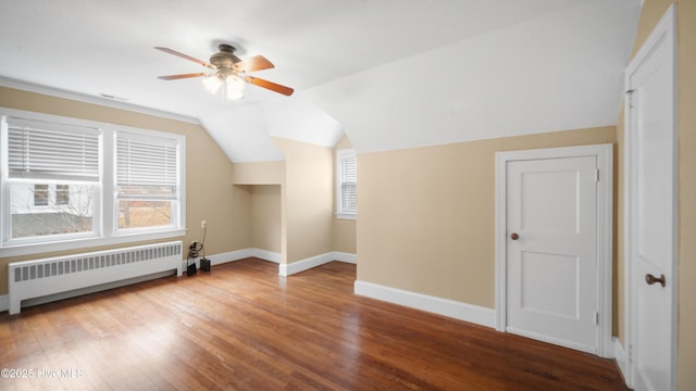 bonus room featuring lofted ceiling, radiator, a ceiling fan, wood finished floors, and baseboards