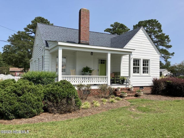 view of front of property with roof with shingles, a porch, crawl space, and a chimney