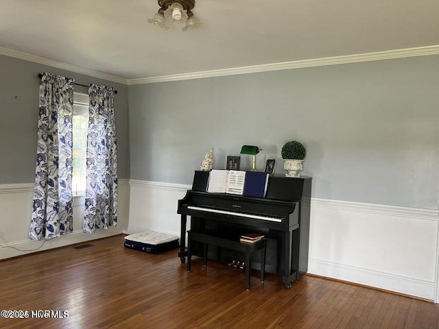 sitting room featuring ornamental molding, wainscoting, and hardwood / wood-style flooring