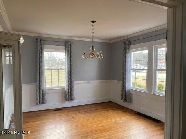 dining area featuring ornamental molding, a notable chandelier, and wood finished floors