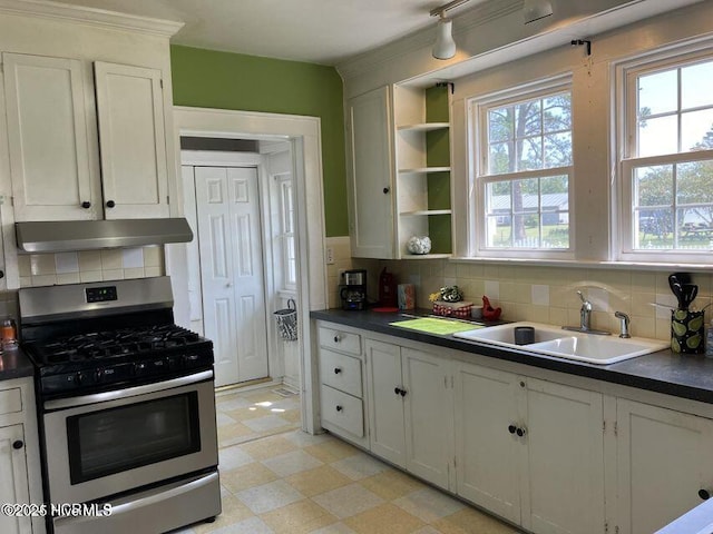 kitchen featuring dark countertops, extractor fan, a sink, and gas stove