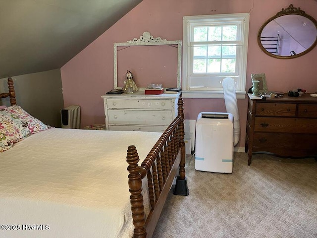 bedroom with lofted ceiling, carpet flooring, and radiator heating unit