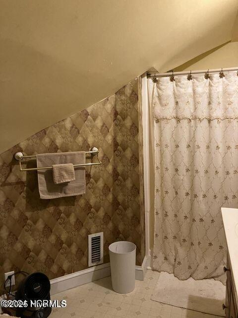 bathroom with lofted ceiling, a shower stall, visible vents, and vanity