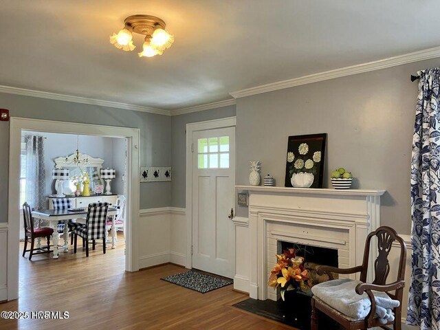 living area featuring plenty of natural light, visible vents, wood finished floors, and ornamental molding