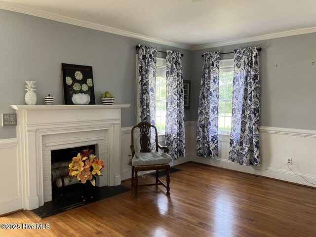 foyer entrance featuring a chandelier, a fireplace with flush hearth, wood finished floors, and crown molding