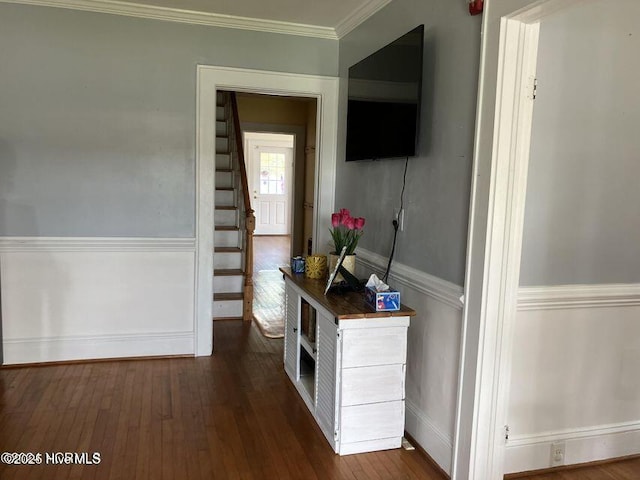 hallway with dark wood-type flooring, crown molding, and stairway