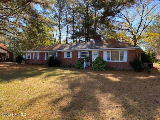 ranch-style home featuring brick siding, crawl space, and a front lawn