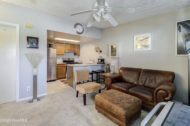 living room with light carpet, ceiling fan, a textured ceiling, and baseboards