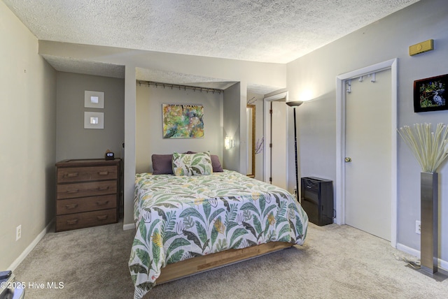 bedroom featuring carpet flooring, a textured ceiling, and baseboards