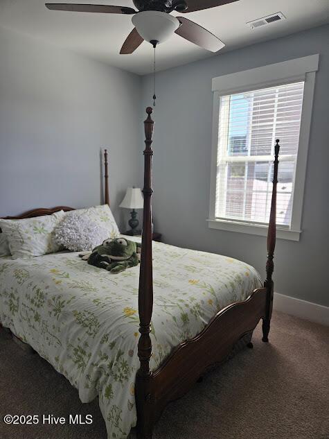 carpeted bedroom with ceiling fan, visible vents, and baseboards