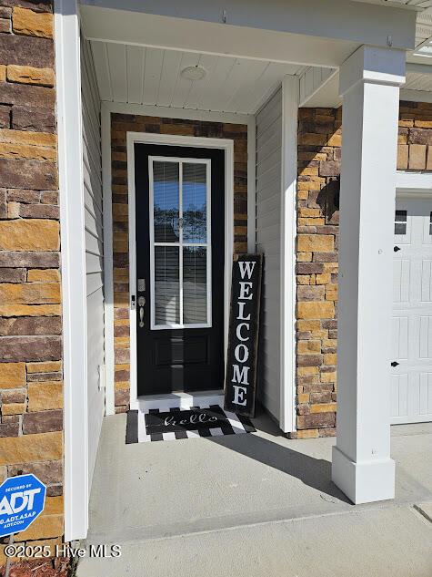 entrance to property featuring brick siding