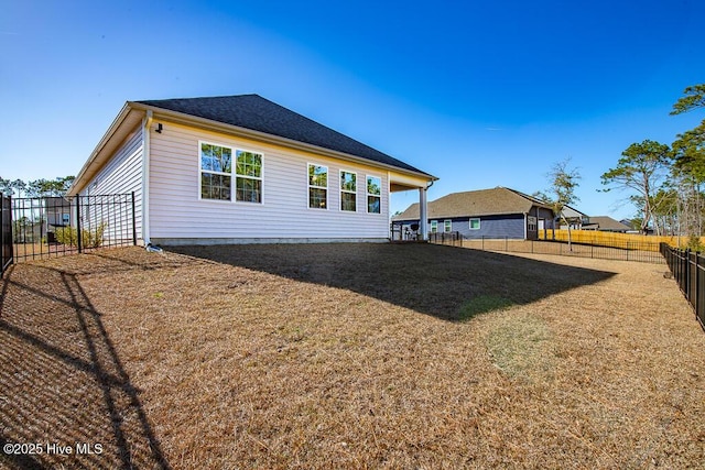 back of property with a lawn and a fenced backyard