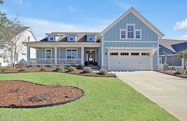 view of front of home with covered porch, an attached garage, board and batten siding, driveway, and a front lawn