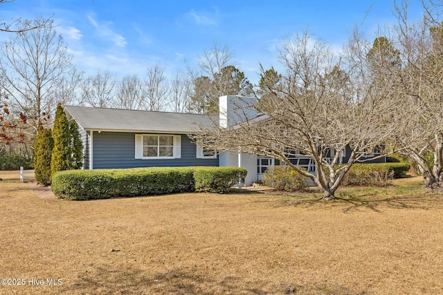 view of front of house with a front lawn and a chimney