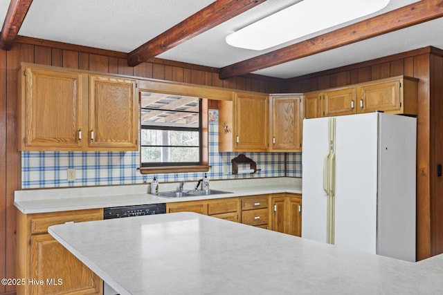 kitchen featuring light countertops, beam ceiling, a sink, and freestanding refrigerator