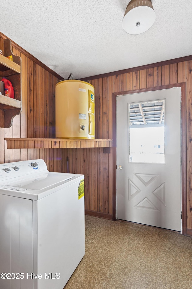 clothes washing area with water heater, wooden walls, a textured ceiling, washer / dryer, and laundry area