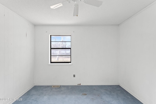 empty room featuring a textured ceiling, carpet floors, and a ceiling fan