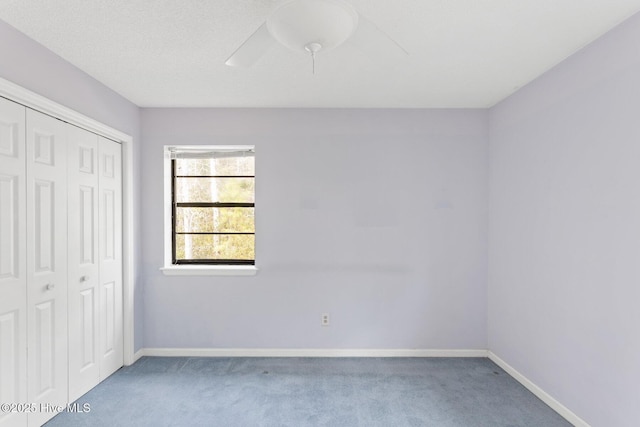 unfurnished bedroom featuring carpet, baseboards, ceiling fan, and a closet