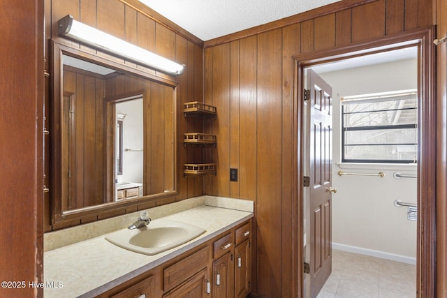 bathroom featuring wooden walls, baseboards, and vanity