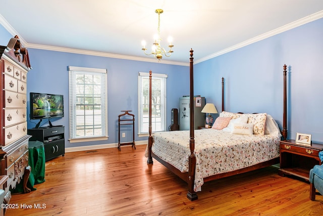 bedroom featuring crown molding, baseboards, wood finished floors, and a notable chandelier