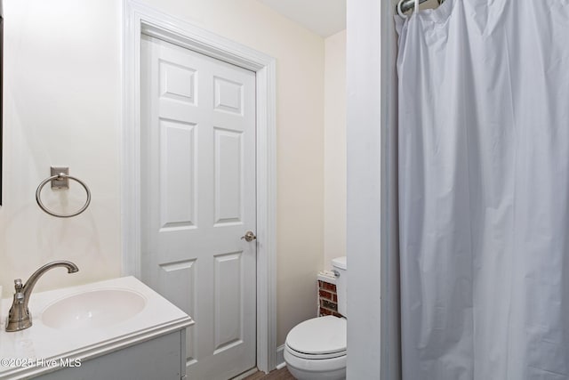 bathroom featuring toilet, curtained shower, and vanity