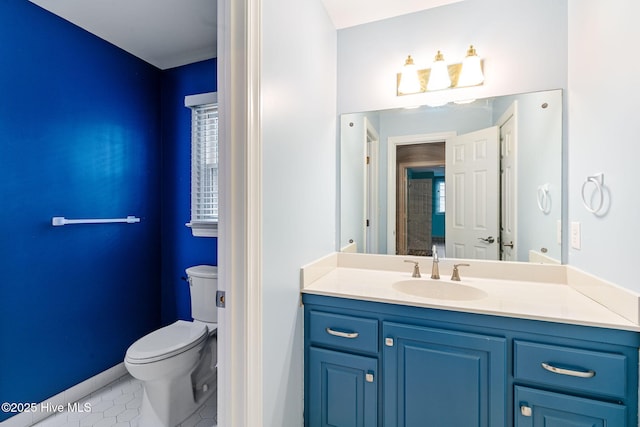 bathroom with toilet, tile patterned floors, baseboards, and vanity