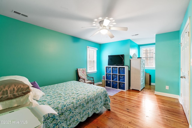 bedroom with baseboards, wood finished floors, and visible vents