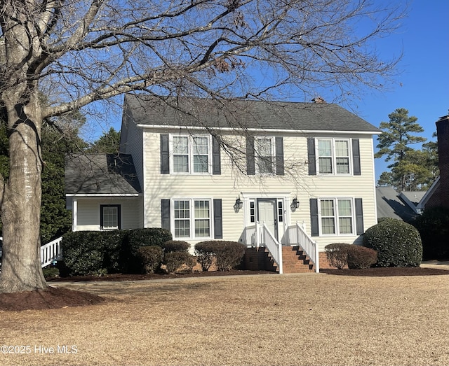 colonial inspired home with a shingled roof