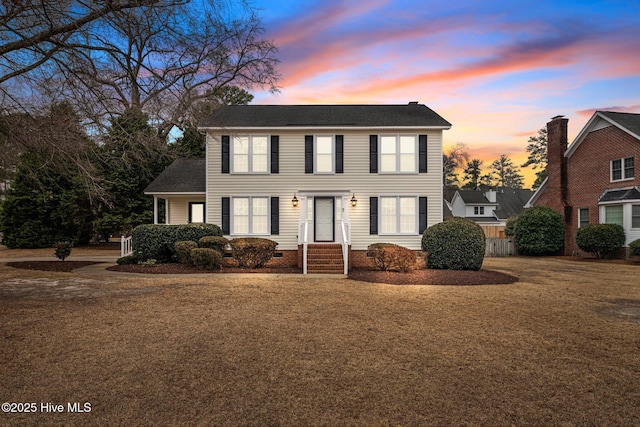 colonial house featuring crawl space and a front lawn