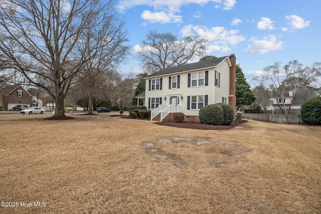 view of front of house featuring crawl space, a chimney, fence, and a front lawn