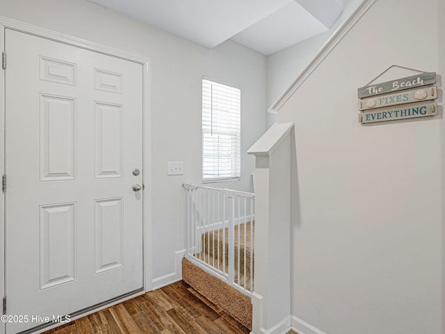 foyer entrance with wood finished floors and baseboards