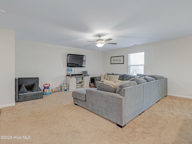 carpeted living area with ceiling fan and baseboards