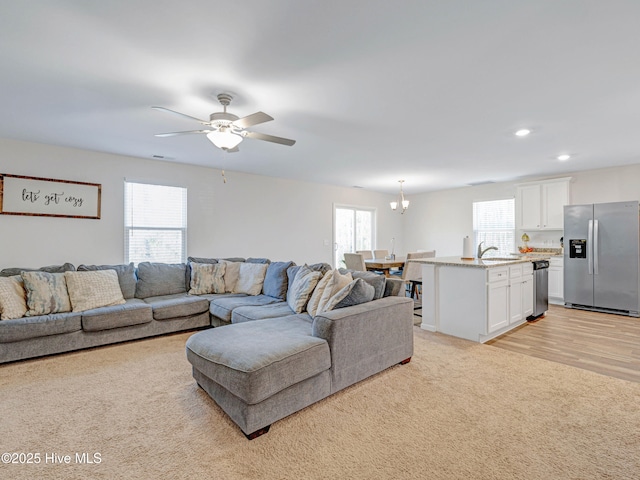 living room featuring visible vents, light colored carpet, a ceiling fan, and recessed lighting