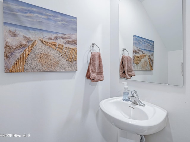 bathroom with vaulted ceiling and a sink