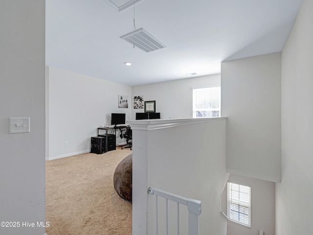 hallway featuring carpet floors, attic access, visible vents, and an upstairs landing