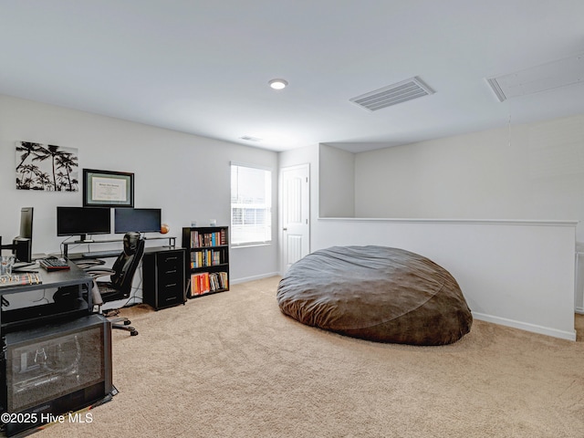 carpeted office space with baseboards, visible vents, and attic access