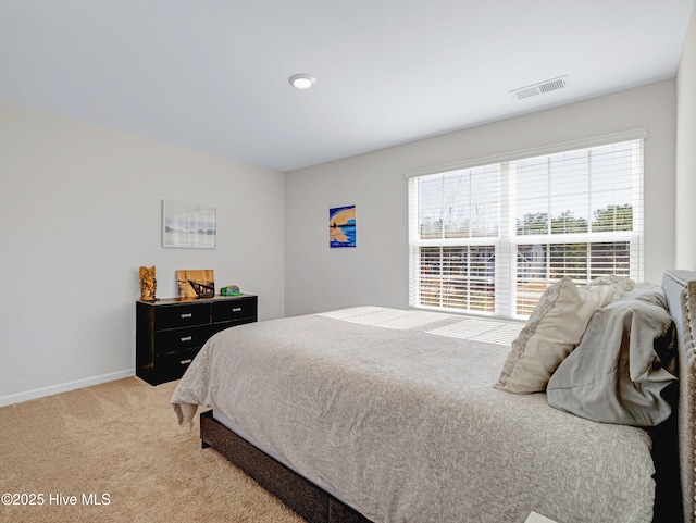 bedroom featuring visible vents, light carpet, and baseboards