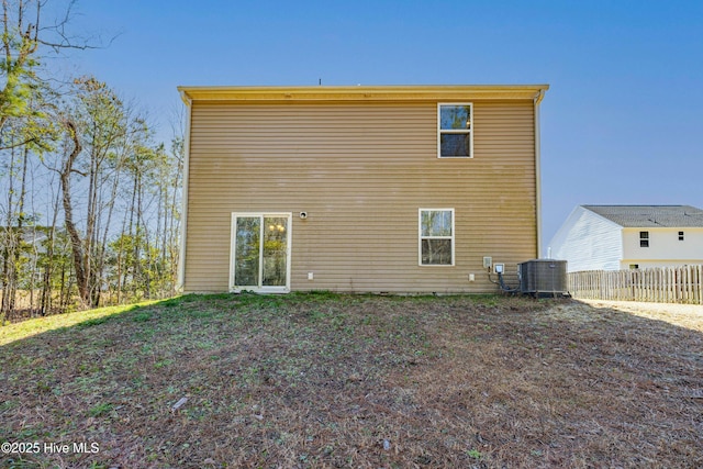 rear view of house with fence and central AC unit