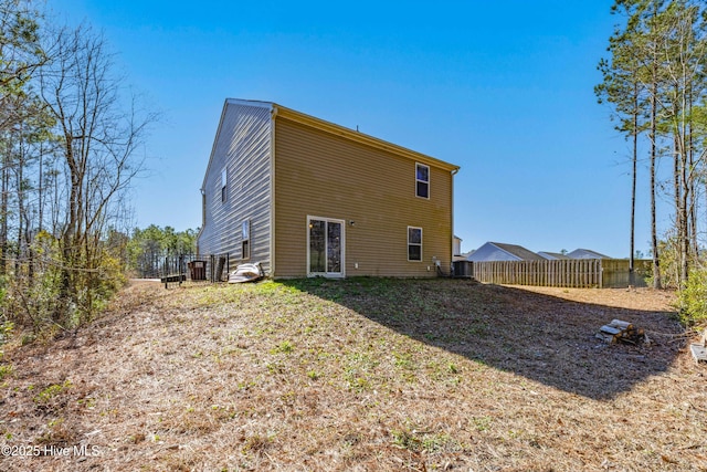 rear view of house featuring fence and central air condition unit