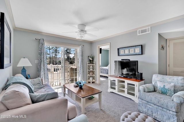 carpeted living room with ornamental molding, visible vents, and a ceiling fan