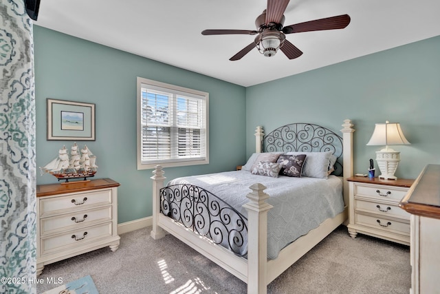 bedroom featuring light carpet, a ceiling fan, and baseboards